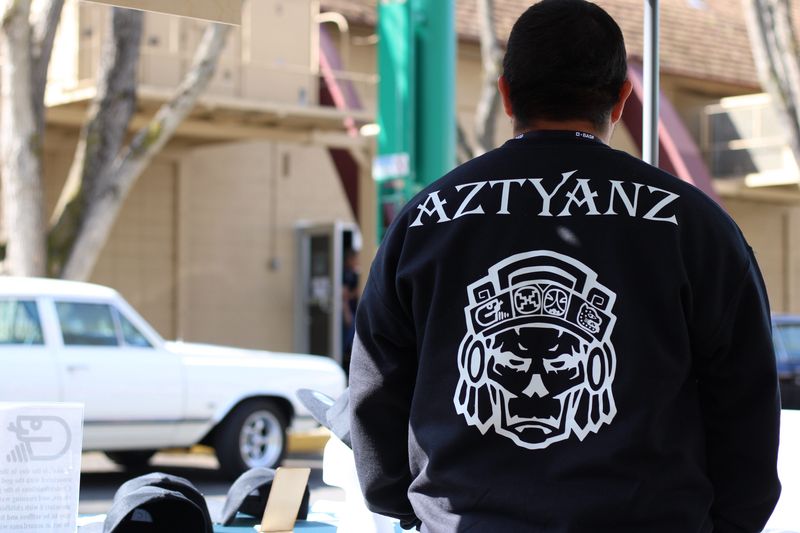 Person wearing the black Aztyanz sweater with white back artwork